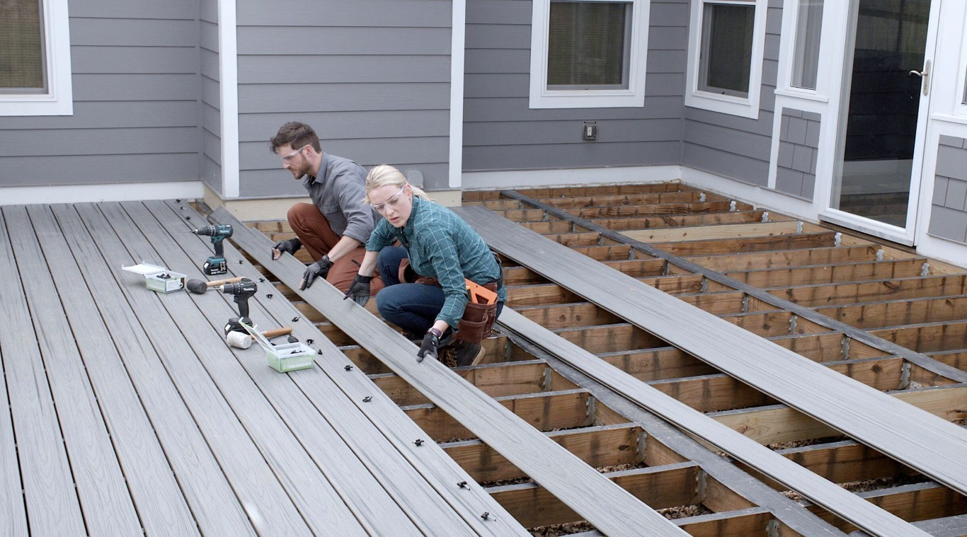 Professional deck builders installing composite decking